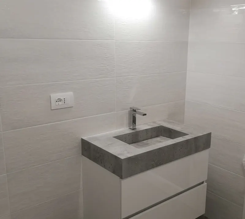 Bagno rifatto, con lavabo in pietra e rivestimento chiaro