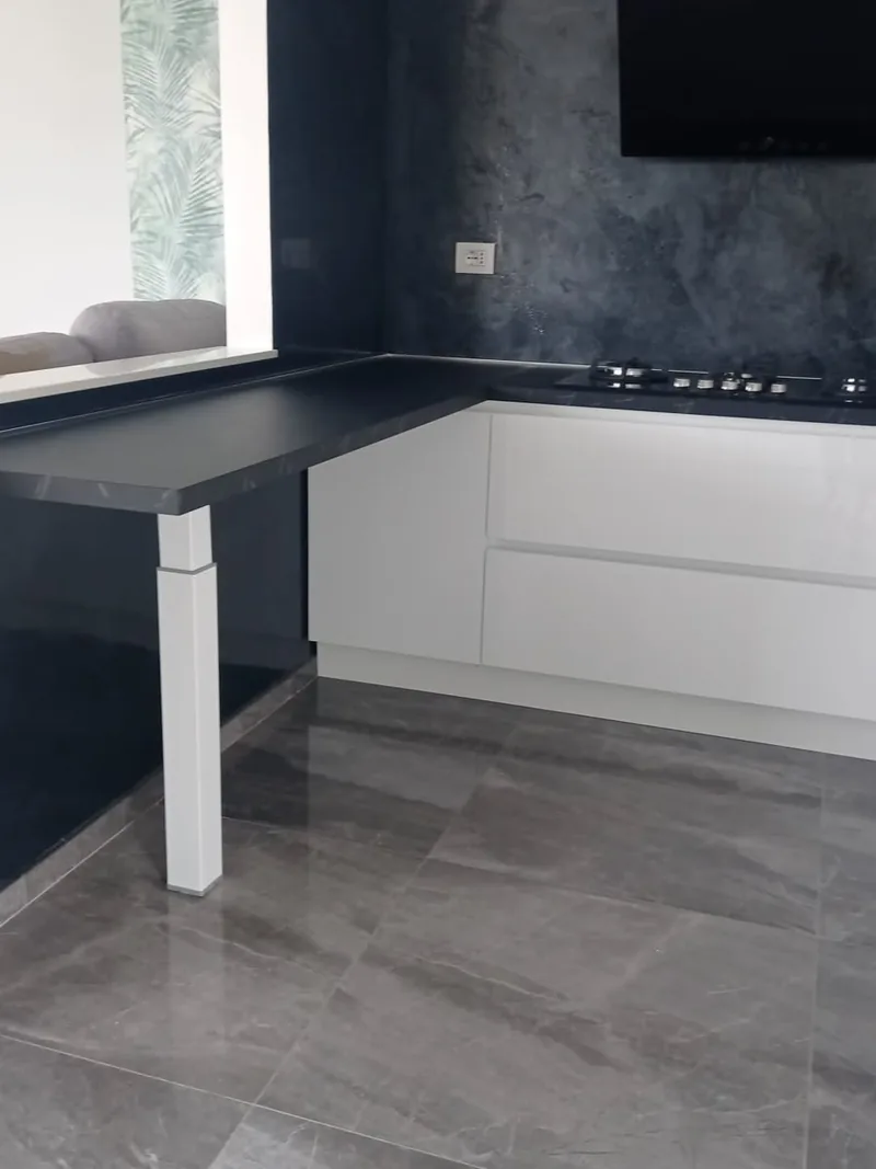 Cucina con penisola, piano scuro e pavimento in gres