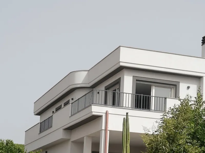 Angolo superiore di una casa, con parapetto curvo e balcone