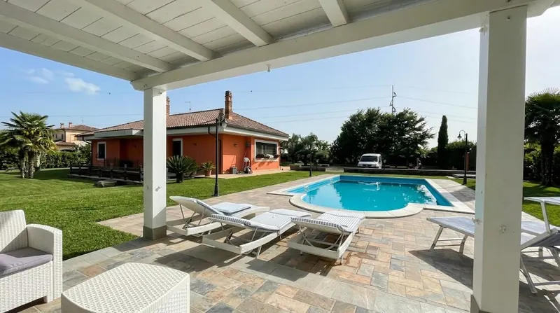 Villa con piscina, vista da un pergolato