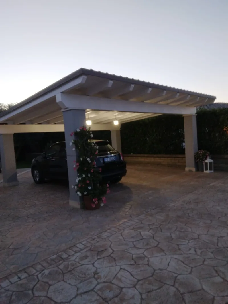 Tettoia in muratura sopra il posto auto, con pavimentazione esterna