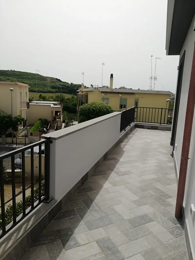 Terrazzo di un’abitazione con pavimentazione nuova e ringhiera in ferro
